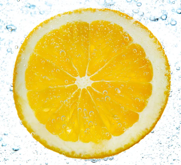 Slice of orange in the water with bubbles, isolated on white — Stok Foto