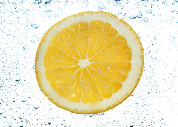 Rebanada de naranja en el agua con burbujas, aislado en blanco — Foto de Stock