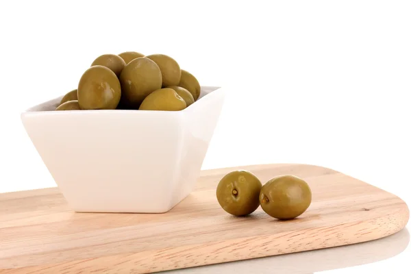Grüne Oliven in weißer Schüssel an Bord isoliert auf weißer — Stockfoto