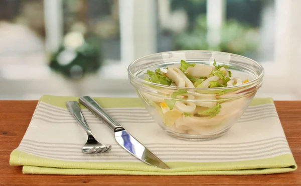 Sallad med bläckfiskringar, citron och sallad i en skål på träbord clo — Stockfoto