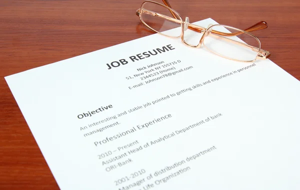 Closeup of resume with glasses on wooden table — Stock Photo, Image