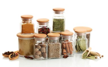 Kavanozlar ve tahta kaşıklar üzerinde beyaz izole baharatlar ile