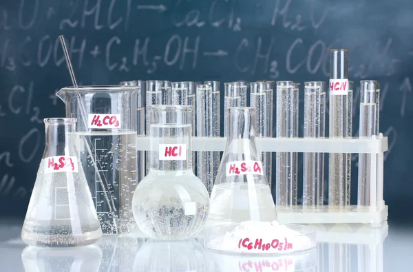 Tubos de ensaio com vários ácidos e outros produtos químicos no fundo do — Fotografia de Stock