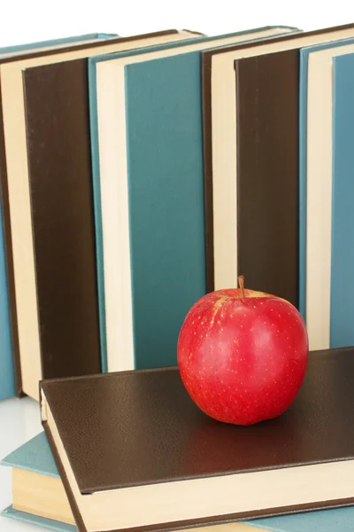 Libri blu e neri con mela su sfondo bianco primo piano — Foto Stock