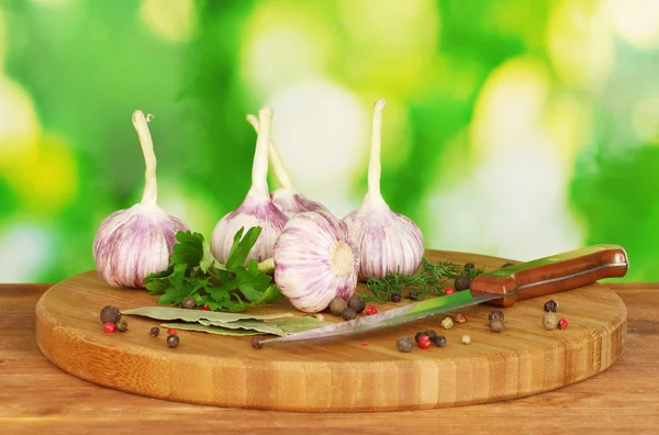 Aglio giovane sul tagliere con verde, pepe e coltello sulla linguetta di legno — Foto Stock