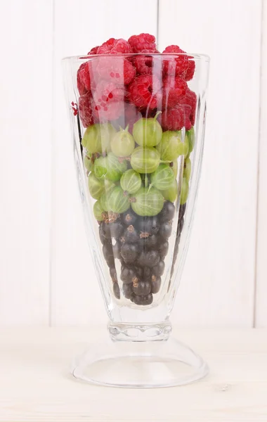 Frutas y bayas mezcladas en vidrio sobre fondo de madera —  Fotos de Stock