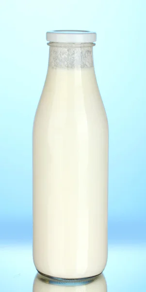 Flasche Milch auf blauem Hintergrund Nahaufnahme — Stockfoto