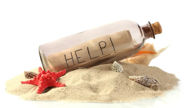 Glazen flesje met opmerking binnen op zand geïsoleerd op wit — Stockfoto
