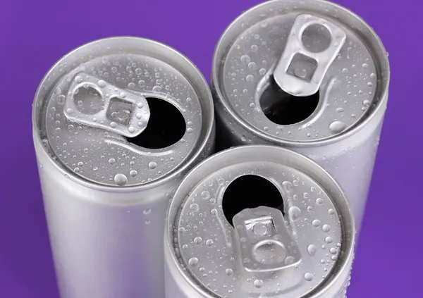 Aluminiumdosen mit Wassertropfen auf violettem Hintergrund — Stockfoto