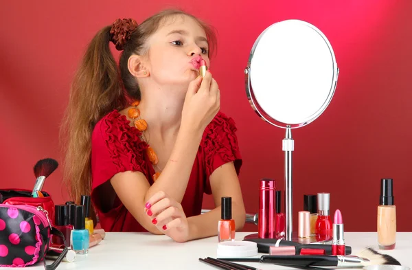 Menina no vestido de sua mãe, está tentando pintar seus lábios — Fotografia de Stock