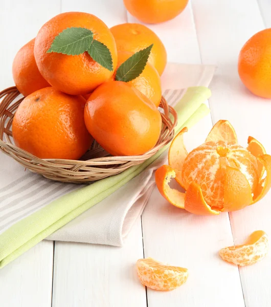 Tangerines με αφήνει σε ένα όμορφο καλάθι, στο λευκό ξύλινο τραπέζι — Φωτογραφία Αρχείου