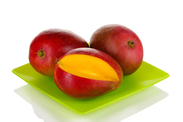 Modne appetitvækkende mango på grøn plade isoleret på hvid - Stock-foto