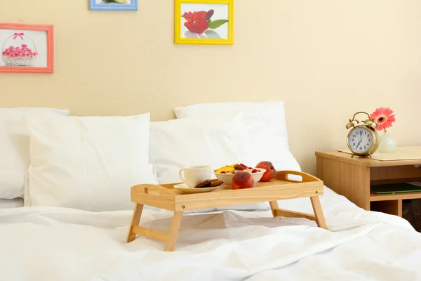 Dřevěný podnos s lehkou snídaní na posteli — Stock fotografie