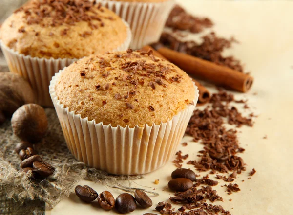 チョコレート、スパイス、コーヒーの種子、ベージュ色の背景上でおいしいマフィン ケーキ — ストック写真