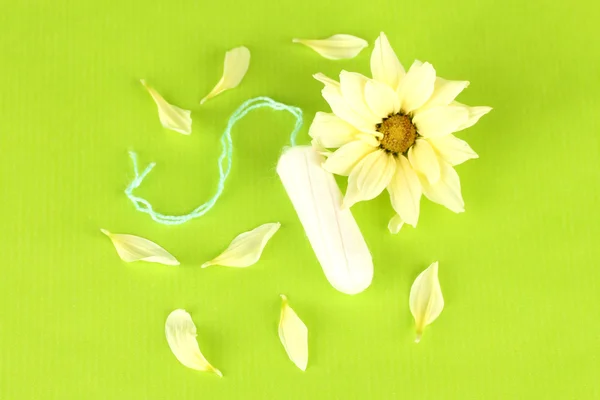 녹색 배경 클로즈업에 노란색 꽃과 함께 면 생리대 — 스톡 사진