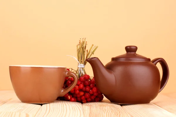 Tee mit rotem Viburnum auf Tisch auf beigem Hintergrund — Stockfoto