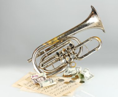 gri arka plan üzerinde para ile müzik aleti