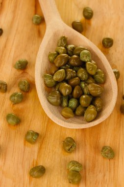 ahşap arka plan yakın çekim üzerinde tahta kaşık içinde yeşil Kapari