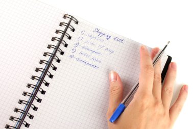 Kadının elinde alışveriş listesi olan bir defter var.