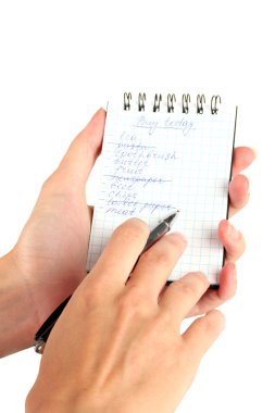 Kadının elinde alışveriş listesi olan bir defter var.