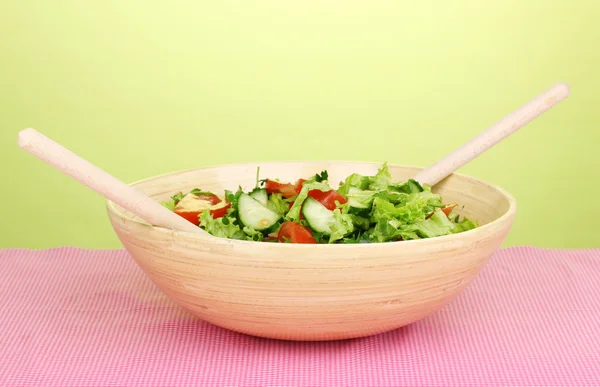 Fresh salad with tomatoes and cucumbers on green background — Stock Photo, Image