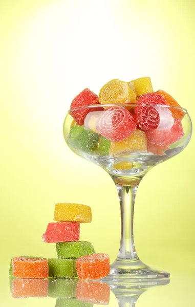 Colorful jelly candies in in cocktail glass on green background — Stock Photo, Image