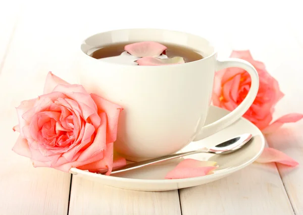 Tasse Tee mit Rosen auf weißem Holztisch — Stockfoto