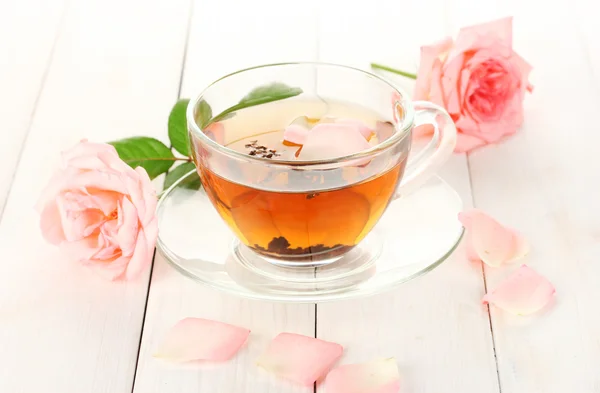 Xícara de chá com rosas na mesa de madeira branca — Fotografia de Stock