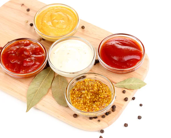 Various sauces on chopping board isolated on white — Stock Photo, Image