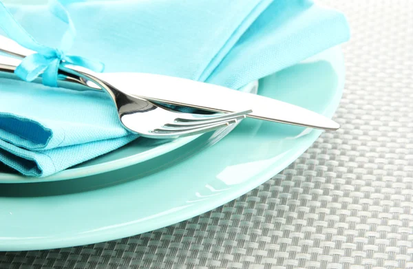 Platos vacíos azules con tenedor y cuchillo sobre un mantel gris —  Fotos de Stock