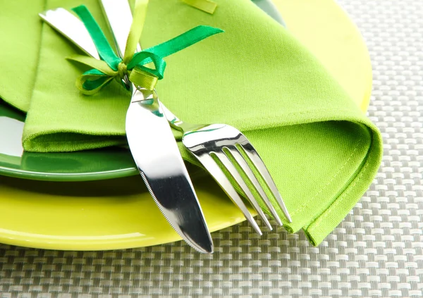 Placas verdes vazias com garfo e faca em uma toalha de mesa cinza — Fotografia de Stock