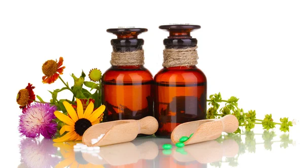 Medicin flaskor med tabletter och blommor isolerad på vit — Stockfoto