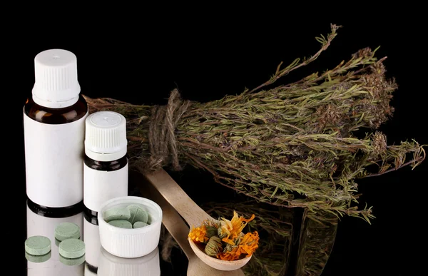 Bottles of medicines and herbs on black background. concept of homeopathy — Stock Photo, Image