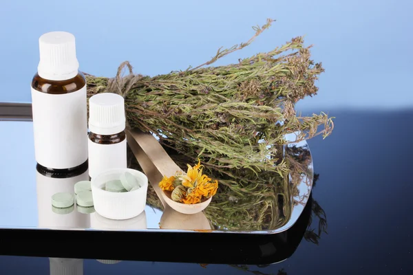Garrafas de medicamentos e ervas no fundo azul. conceito de homeopatia — Fotografia de Stock