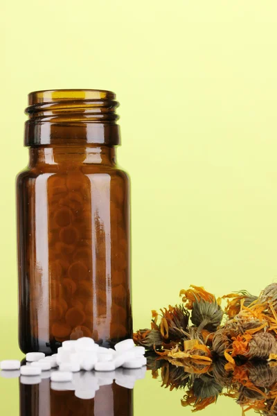 Fles met pillen en kruiden op groene achtergrond. concept van de homeopathie — Stockfoto