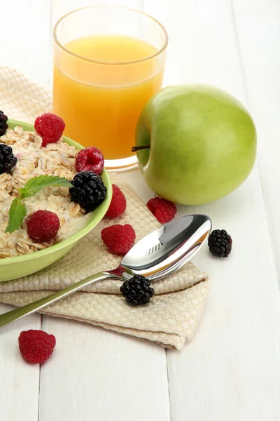 Leckeres Haferbrei mit Beeren und einem Glas Saft auf weißem Holztisch — Stockfoto