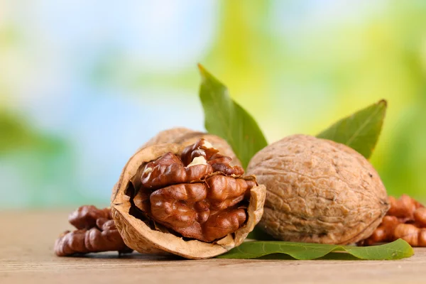 Nueces con hojas verdes, sobre fondo verde —  Fotos de Stock