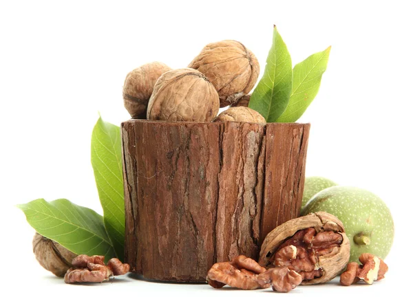 Vlašské ořechy se zelenými listy v woooden vázu, izolované na bílém — Stock fotografie