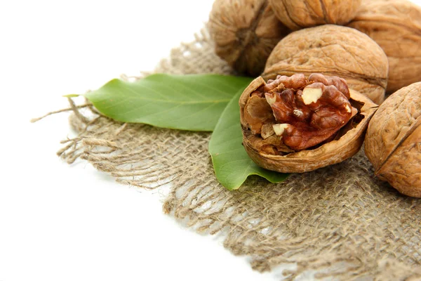 Vlašské ořechy se zelenými listy na pytlovina, izolované na bílém — Stock fotografie