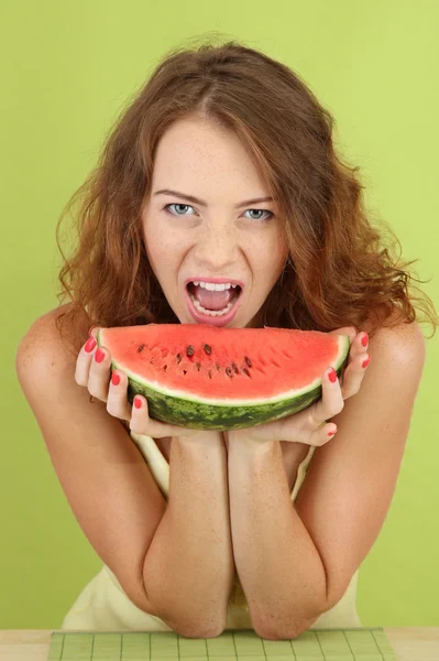 Usmívající se krásná dívka s meloun na zeleném pozadí — Stock fotografie