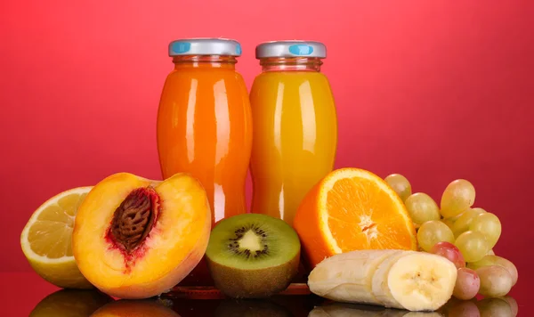 병에 과일 옆에 분홍색 backgro multifruit 맛 있는 주스 — 스톡 사진