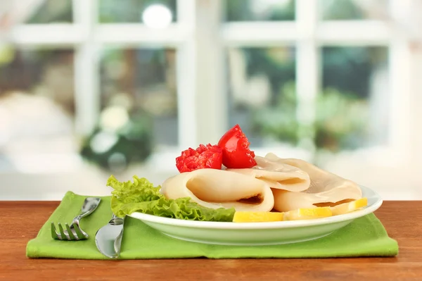 Boiled squids with vegetables on the plate on wooden table close-up — Stock Photo, Image