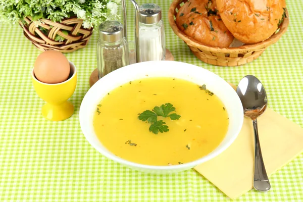 Geurige soep in witte plaat op groene tafellaken close-up — Stockfoto
