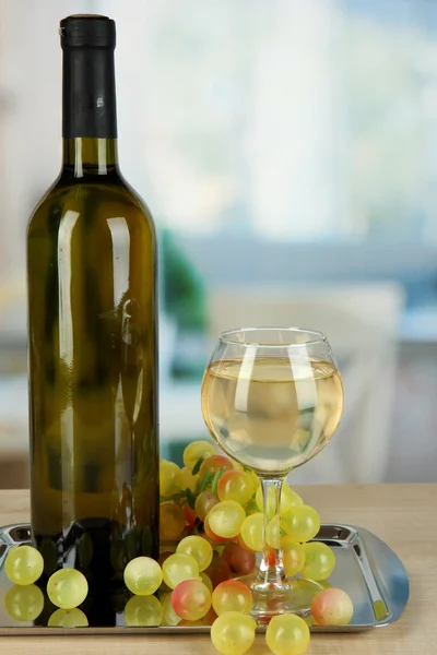 White wine in glass with bottle on salver on room background — Stock Photo, Image