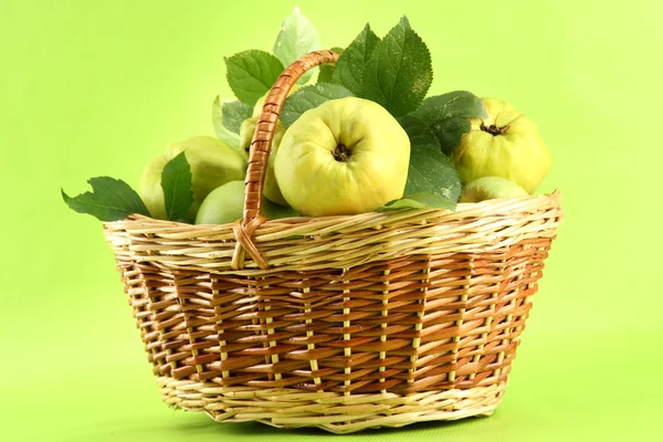 Söt kvittenfrukter med blad i korg, på grön bakgrund — Stockfoto