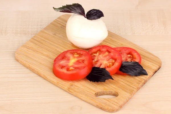 まな板ボード マットの上にトマトと美味しいモッツァレラチーズ — ストック写真