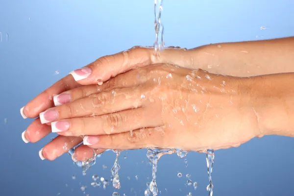 女人的洗手上蓝色背景特写 — 图库照片