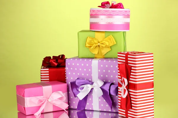 Yeşil arka plan üzerinde renkli hediyeler — Stok fotoğraf
