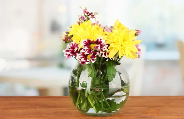 Colorful bouquet of chrysanthemums in a glass vase on wooden table close-up — Stock Photo, Image