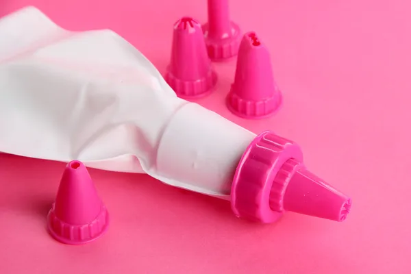 Saco de confeitaria e bocais substituíveis, sobre fundo rosa — Fotografia de Stock